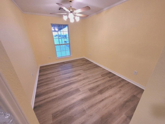 empty room featuring crown molding, wood-type flooring, and ceiling fan