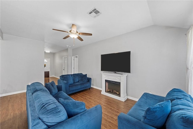 living area featuring visible vents, a fireplace, baseboards, and wood finished floors