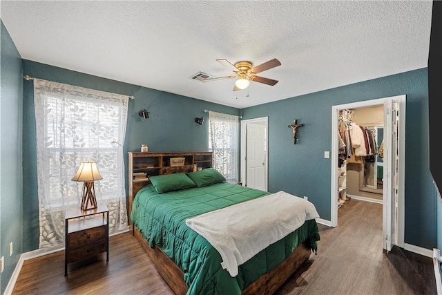 bedroom with multiple windows, wood finished floors, and visible vents