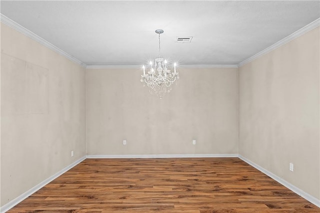 empty room featuring ornamental molding, wood-type flooring, and a notable chandelier