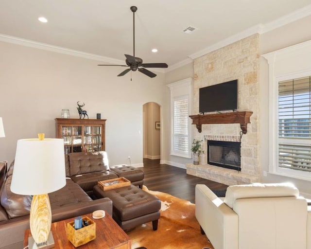 living room featuring crown molding, ceiling fan, a fireplace, and hardwood / wood-style flooring