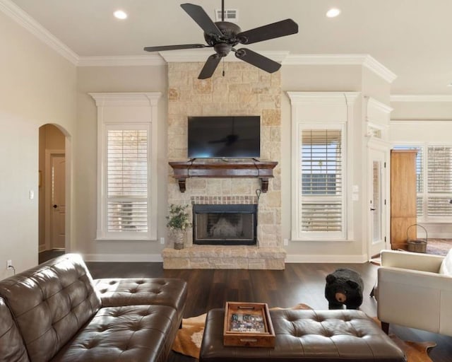 living room with dark hardwood / wood-style flooring, a fireplace, ornamental molding, and plenty of natural light