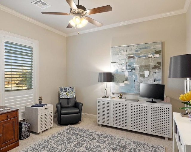 sitting room with light carpet, ornamental molding, and ceiling fan