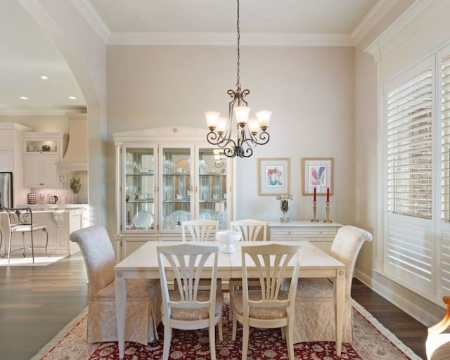 dining space featuring ornamental molding, dark hardwood / wood-style flooring, and a notable chandelier