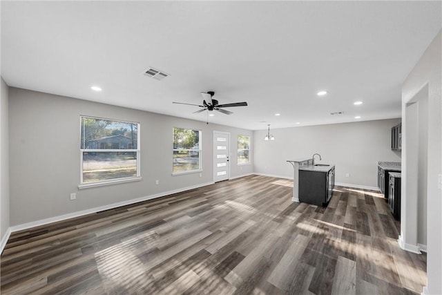 unfurnished living room with dark hardwood / wood-style flooring, ceiling fan, and sink