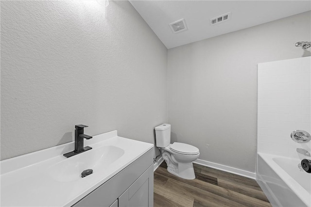 full bathroom with hardwood / wood-style floors, vanity, shower / bathtub combination, and toilet