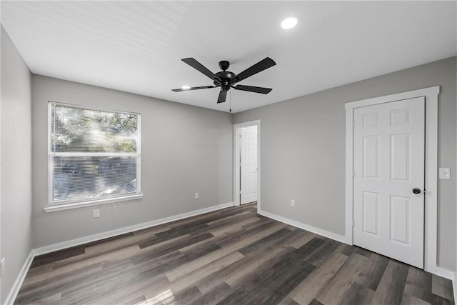 unfurnished bedroom with ceiling fan and dark wood-type flooring