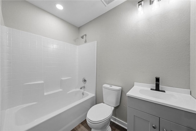 full bathroom featuring hardwood / wood-style floors, vanity, toilet, and tub / shower combination