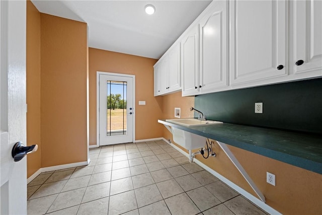 washroom with cabinets, sink, light tile patterned floors, and washer hookup