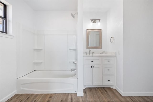 bathroom featuring hardwood / wood-style flooring,  shower combination, and vanity