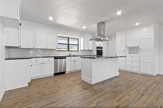 kitchen featuring hardwood / wood-style floors, stainless steel appliances, a center island, white cabinets, and island exhaust hood