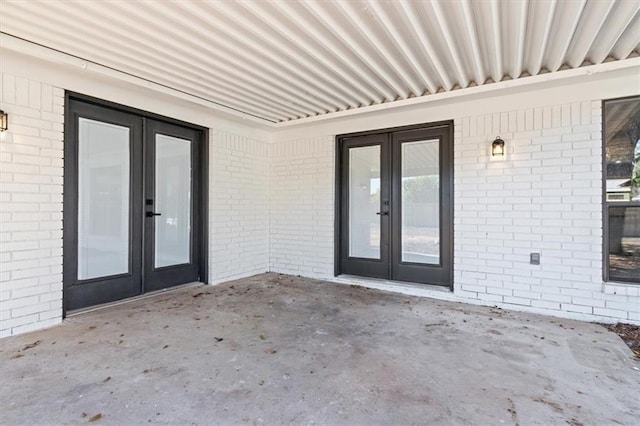 view of exterior entry featuring a patio and french doors