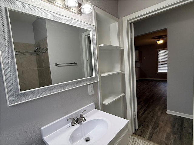 bathroom featuring vanity, tiled shower, hardwood / wood-style floors, and built in shelves