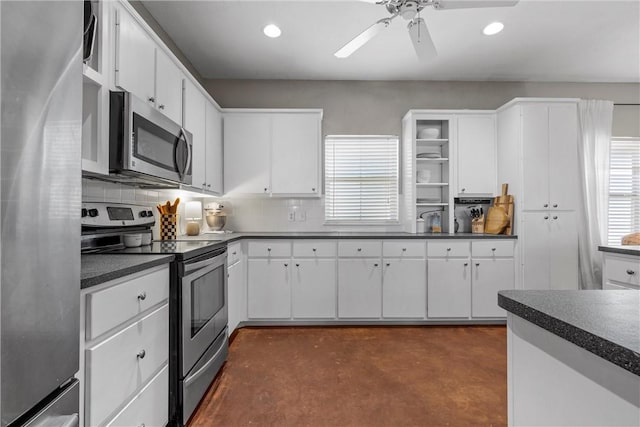 kitchen with dark countertops, concrete flooring, stainless steel appliances, and decorative backsplash