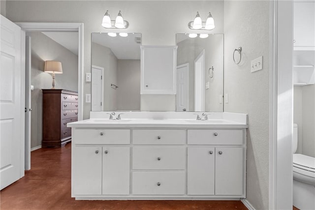 full bathroom with concrete flooring, a sink, toilet, and double vanity