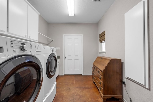 clothes washing area with cabinet space, separate washer and dryer, and a textured ceiling