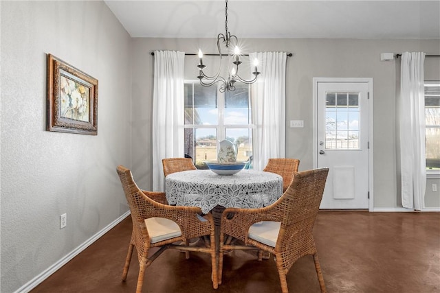 dining area with baseboards, concrete floors, and a notable chandelier