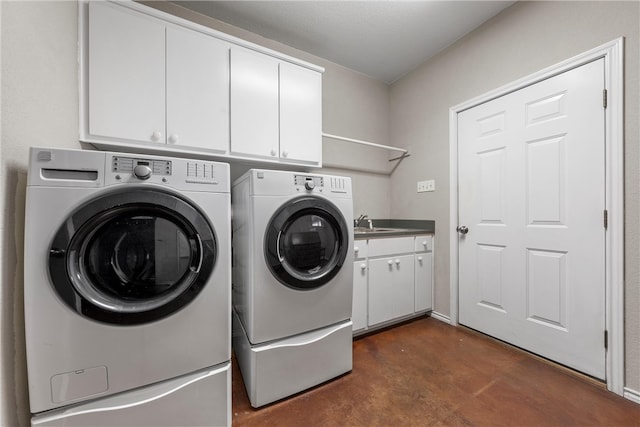 clothes washing area featuring cabinet space, washing machine and dryer, and a sink