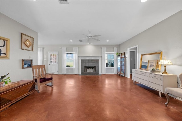 living area featuring finished concrete floors, a tile fireplace, recessed lighting, and a ceiling fan