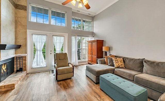 living room featuring hardwood / wood-style floors, french doors, ceiling fan, and a healthy amount of sunlight