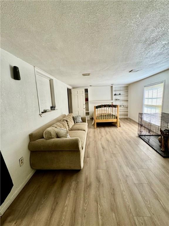 bedroom featuring a textured ceiling and light hardwood / wood-style floors