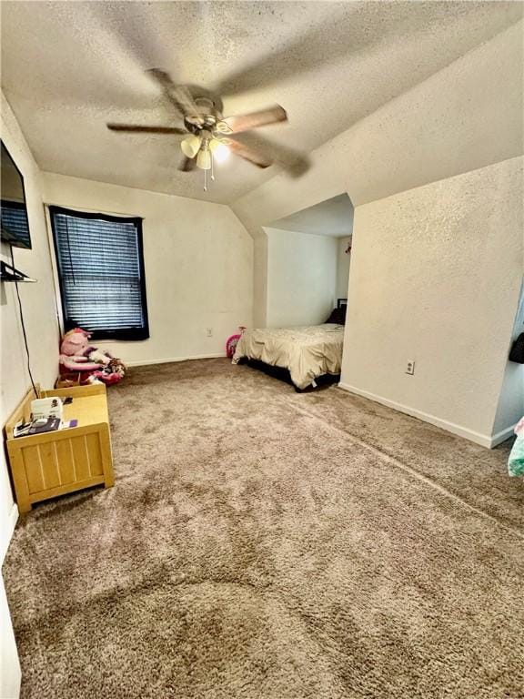 unfurnished bedroom with carpet, a textured ceiling, ceiling fan, and lofted ceiling