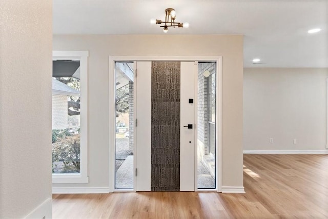 foyer with light hardwood / wood-style floors and an inviting chandelier