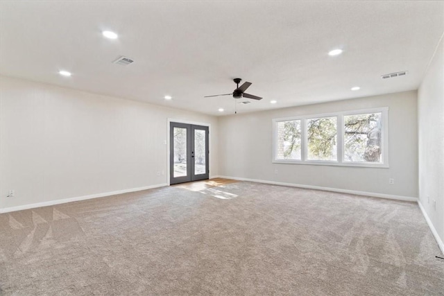 empty room with ceiling fan, light carpet, and french doors