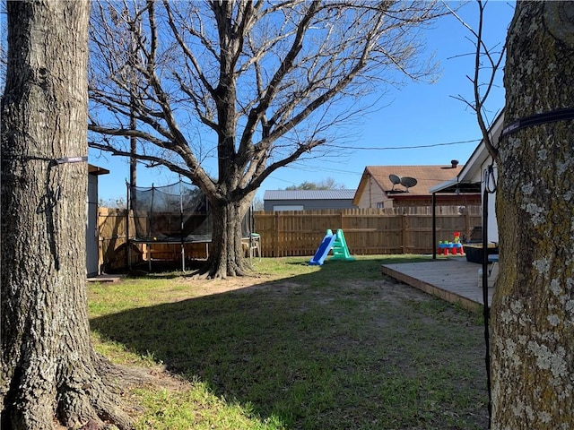 view of yard with a patio area, a trampoline, and a fenced backyard