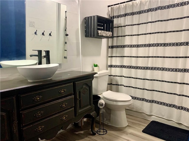 full bath featuring toilet, vanity, a shower with shower curtain, and wood finished floors