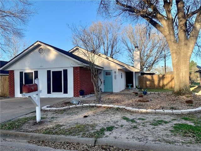 ranch-style house with brick siding, a chimney, and fence