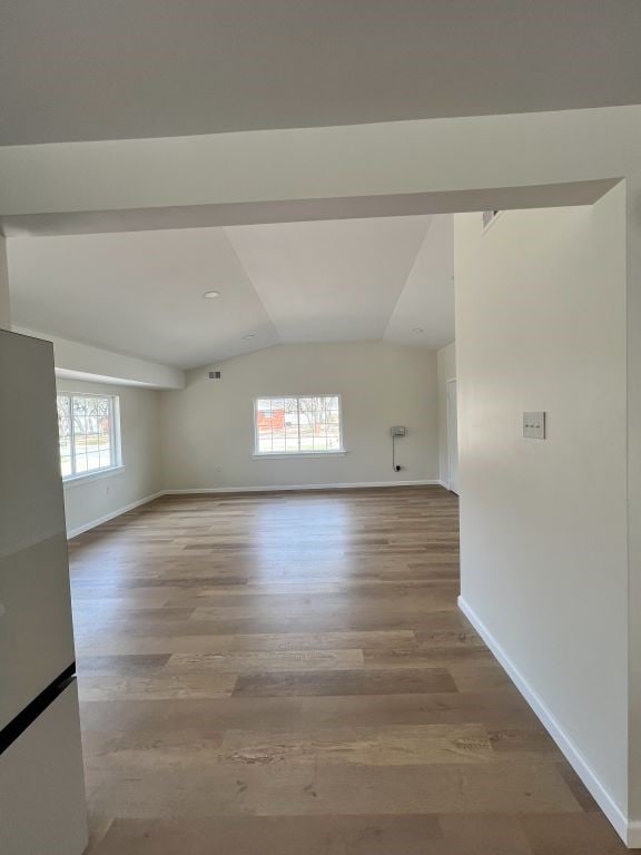 unfurnished room featuring lofted ceiling, wood finished floors, and baseboards