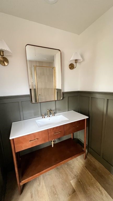 bathroom featuring vanity, wood finished floors, and wainscoting