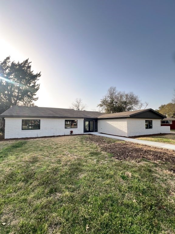 ranch-style home featuring a front lawn