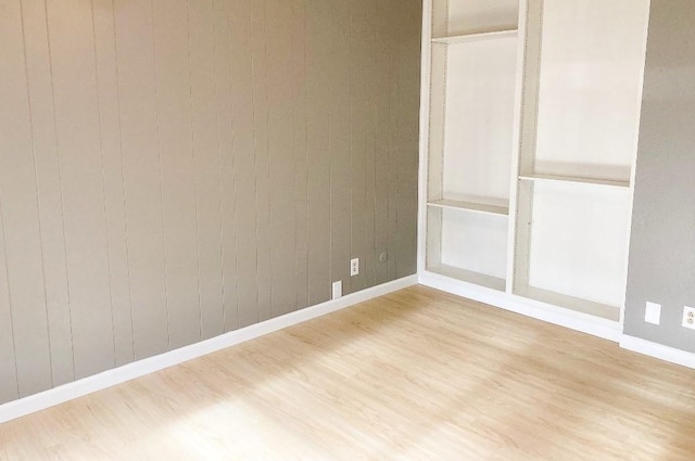 interior space featuring hardwood / wood-style floors and wooden walls