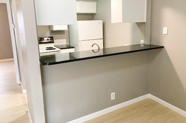 kitchen featuring white cabinetry, light hardwood / wood-style floors, and white appliances