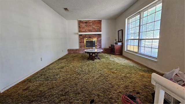 living room with carpet, a textured ceiling, and a brick fireplace