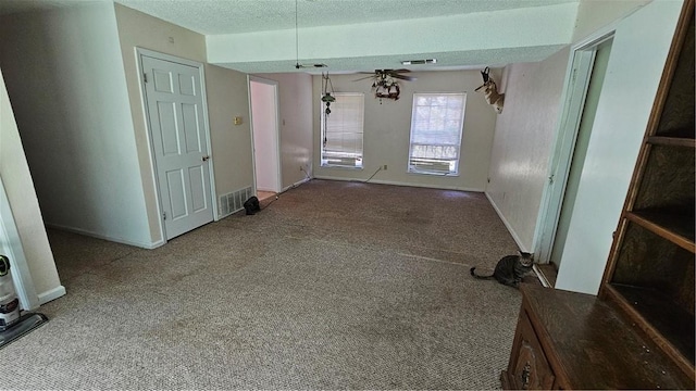 carpeted spare room featuring ceiling fan and a textured ceiling