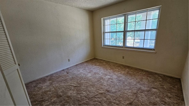 carpeted spare room with a textured ceiling