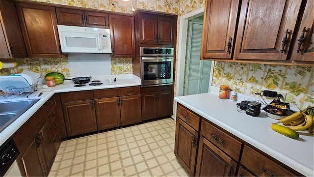 kitchen featuring white appliances and sink