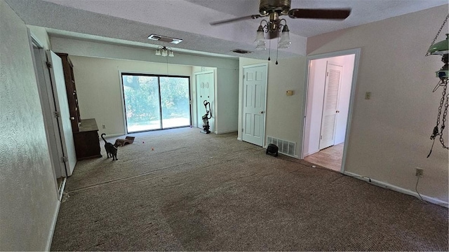 interior space featuring light colored carpet and a textured ceiling