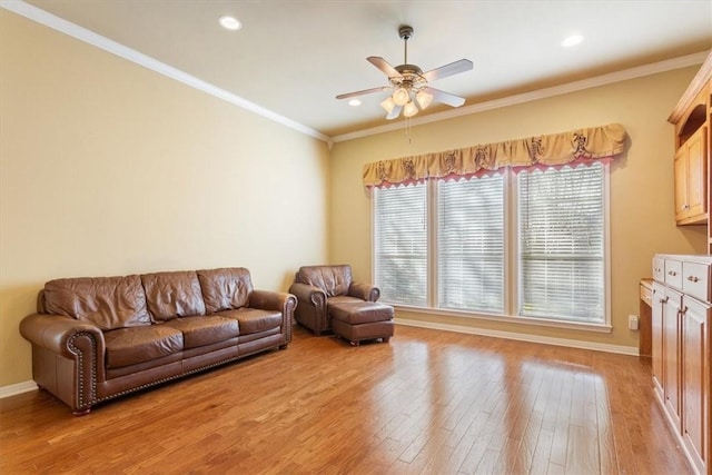 living room with crown molding, ceiling fan, and light hardwood / wood-style floors