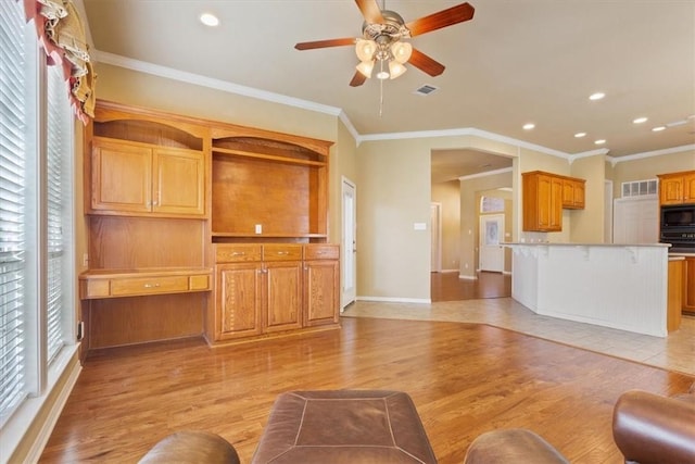 unfurnished living room with crown molding, light hardwood / wood-style floors, and ceiling fan