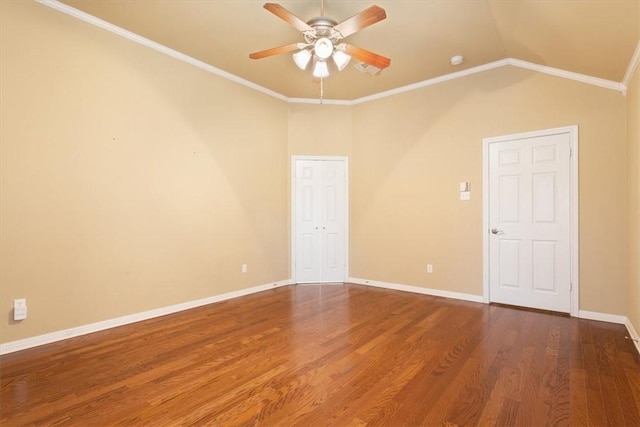 empty room with lofted ceiling, crown molding, wood-type flooring, and ceiling fan