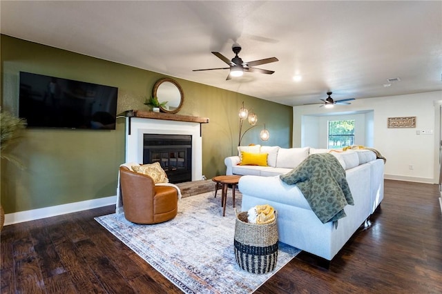 living room featuring a fireplace, dark hardwood / wood-style flooring, and ceiling fan