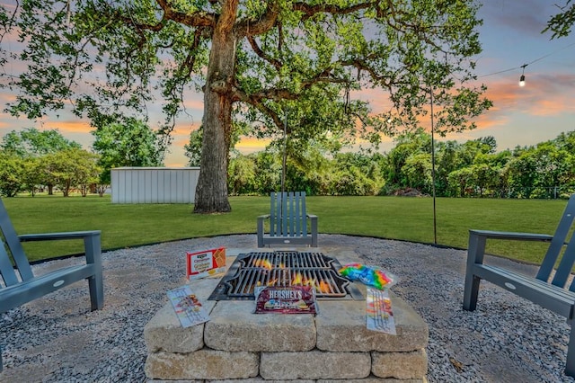 patio terrace at dusk featuring a yard