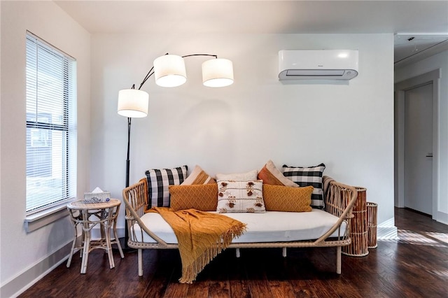 sitting room featuring a wall mounted air conditioner, a healthy amount of sunlight, and dark hardwood / wood-style flooring