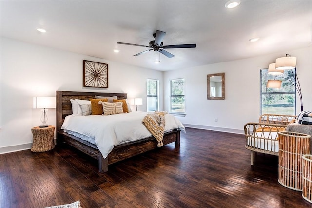 bedroom featuring dark hardwood / wood-style floors, multiple windows, and ceiling fan