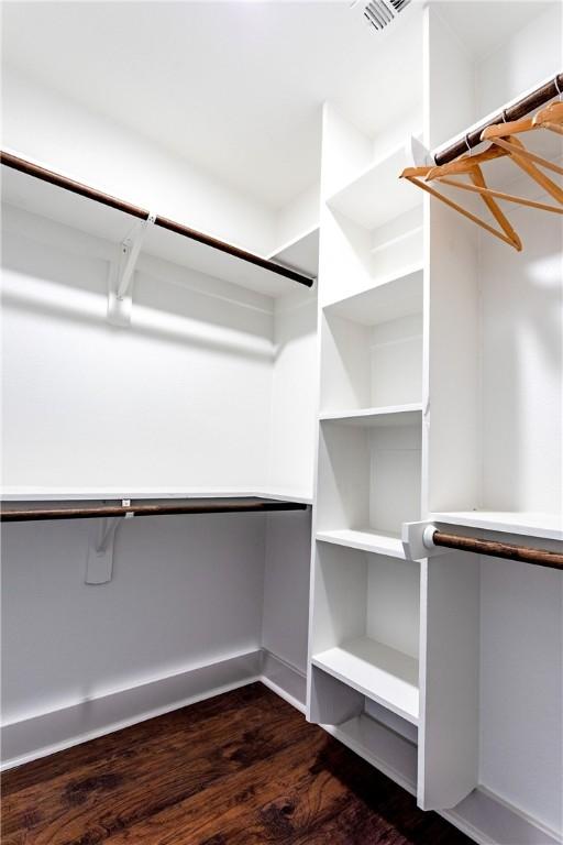 spacious closet with dark wood-type flooring