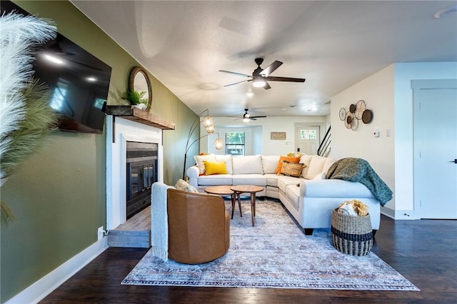 living room featuring ceiling fan and dark hardwood / wood-style flooring